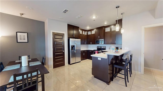 1208 E Camellia Ave Unit 2, Mcallen, TX 78501 - kitchen with stainless steel appliances, light countertops, visible vents, a peninsula, and a breakfast bar area