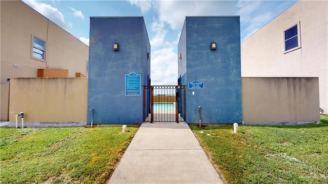 1208 E Camellia Ave Unit 2, Mcallen, TX 78501 - doorway to property featuring fence, a lawn, a gate, and stucco siding