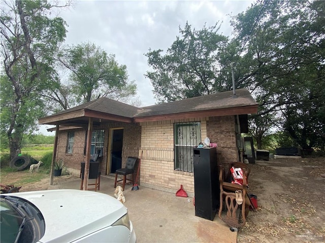 11732 Rogers Rd, Edinburg, TX 78542 - rear view of house featuring brick siding, a patio area, and roof with shingles