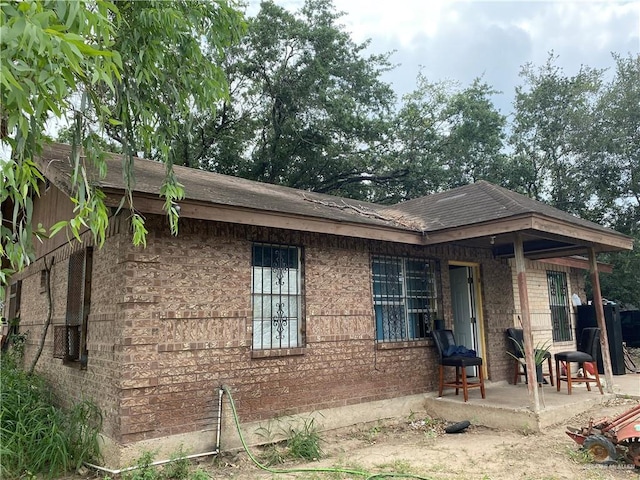 11732 Rogers Rd, Edinburg, TX 78542 - view of property exterior with a patio area, a shingled roof, and brick siding