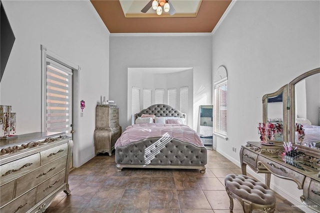 bedroom featuring a towering ceiling, multiple windows, crown molding, and ceiling fan