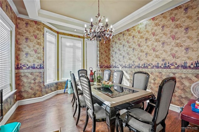 dining space featuring a raised ceiling, crown molding, wood-type flooring, and a notable chandelier