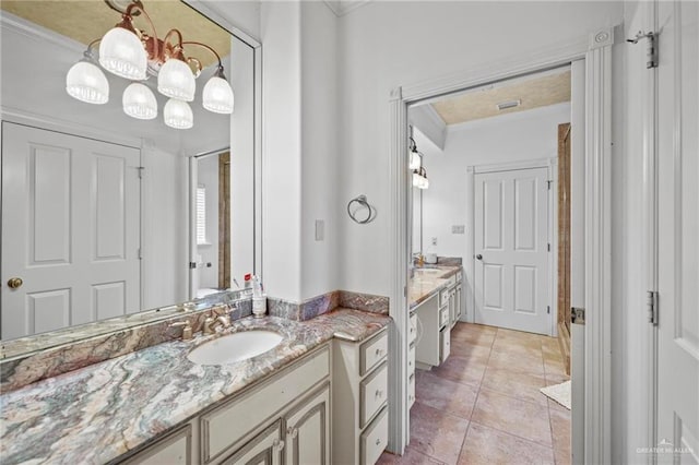 bathroom featuring tile patterned floors, crown molding, and vanity