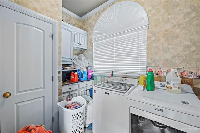 laundry room featuring washing machine and dryer, cabinets, and ornamental molding