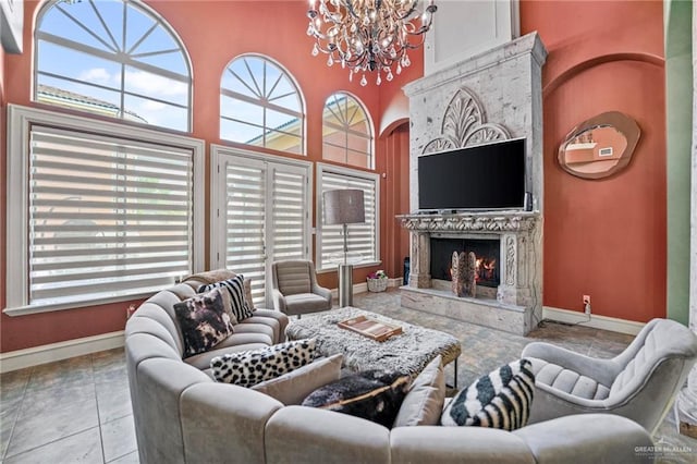 living room featuring light tile patterned flooring, a towering ceiling, and an inviting chandelier