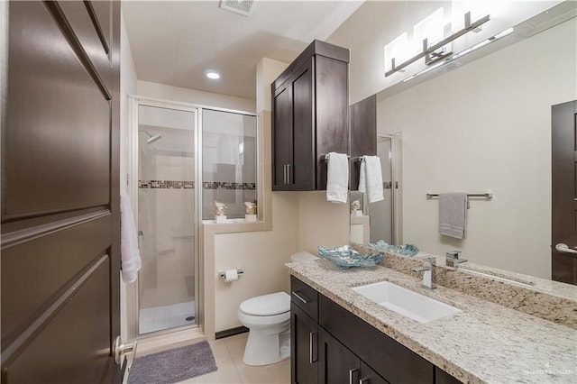 bathroom with tile patterned floors, vanity, toilet, and a shower with door