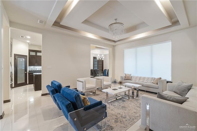 tiled living room featuring a tray ceiling and an inviting chandelier