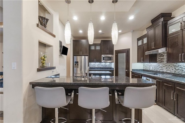 kitchen featuring dark brown cabinets, a kitchen island with sink, and appliances with stainless steel finishes