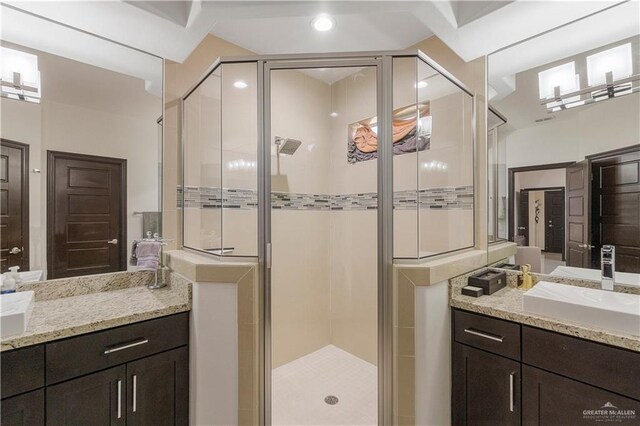 bathroom with a shower with door and vanity