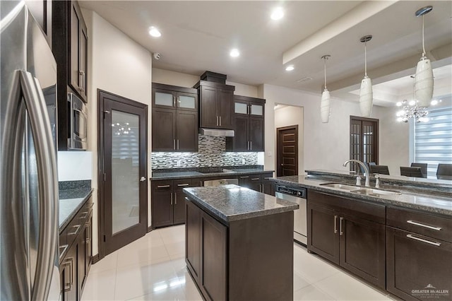 kitchen featuring dark stone counters, sink, a kitchen island, and stainless steel appliances