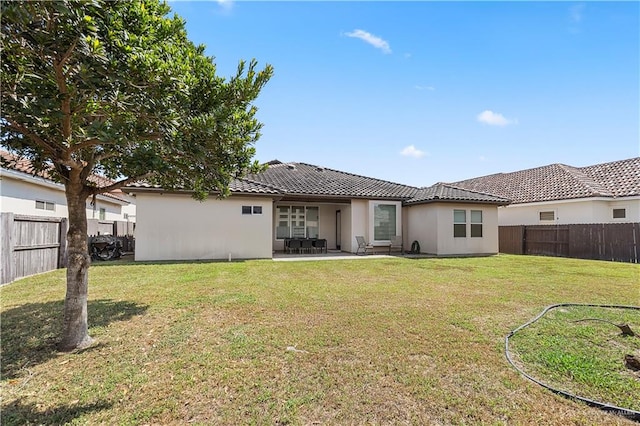 back of property with a patio area and a lawn