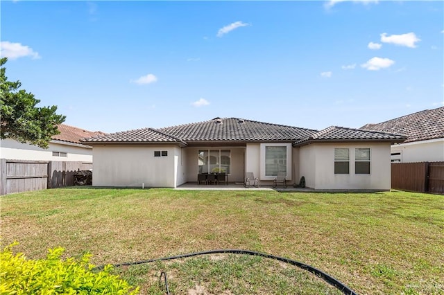 rear view of house featuring a yard and a patio