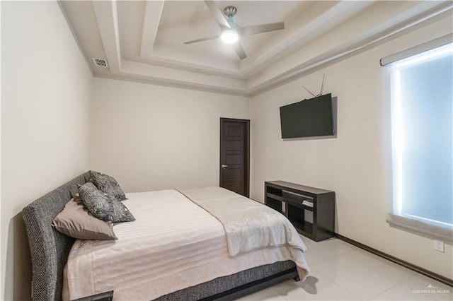 bedroom with ceiling fan and a raised ceiling