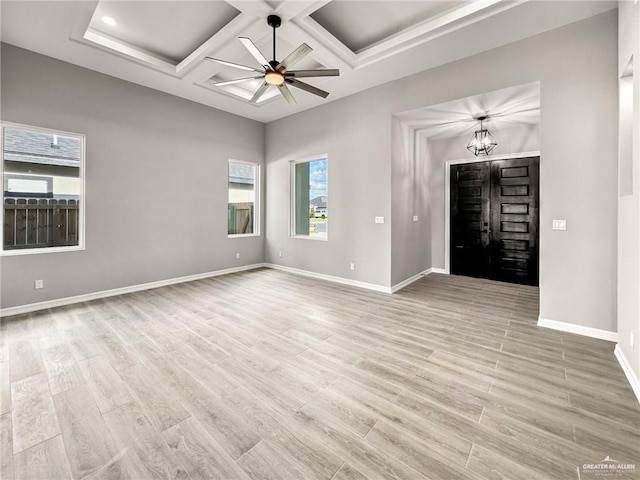 entryway with coffered ceiling, ceiling fan with notable chandelier, and light wood-type flooring