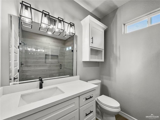 bathroom featuring vanity, a shower with door, and toilet