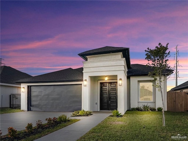 view of front of home with a garage and a yard