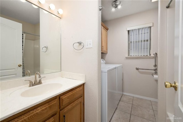 bathroom with separate washer and dryer, vanity, and tile patterned floors