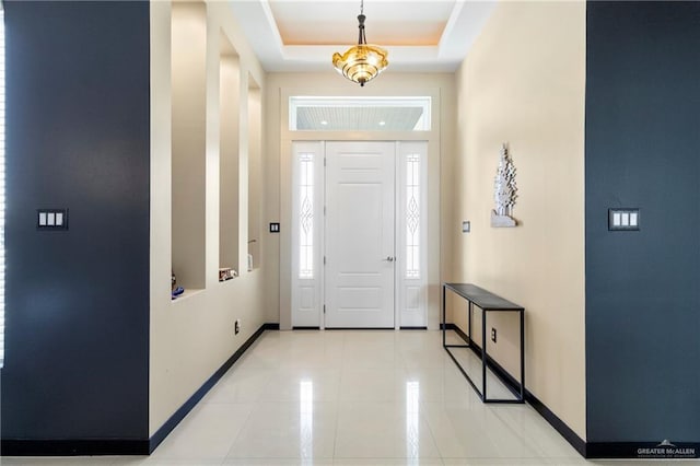 tiled foyer entrance featuring a raised ceiling