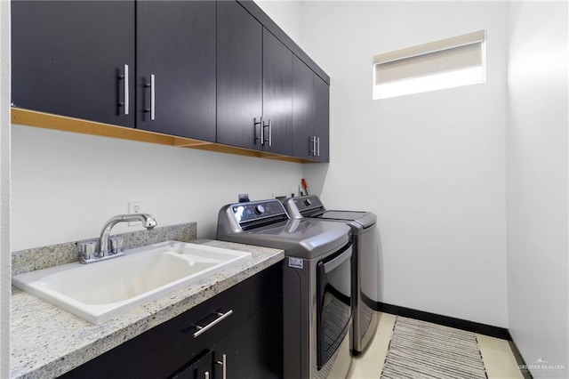 laundry room with cabinets, washer and dryer, and sink