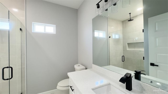 bathroom featuring a shower with door, toilet, and a wealth of natural light