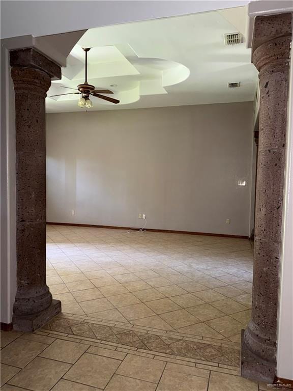 empty room with ceiling fan, ornate columns, and visible vents
