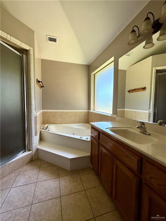 full bath featuring vanity, tile patterned floors, a shower stall, lofted ceiling, and visible vents