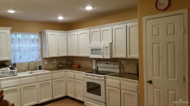 kitchen featuring white cabinetry, white appliances, and sink