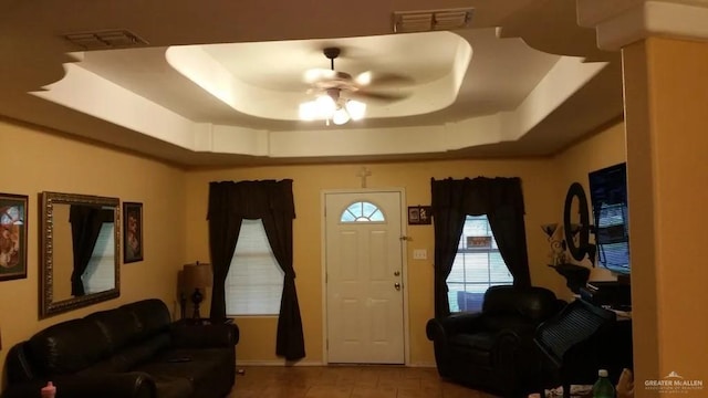 entryway with a tray ceiling and ceiling fan
