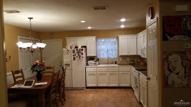 kitchen featuring decorative light fixtures, white cabinetry, white appliances, and sink