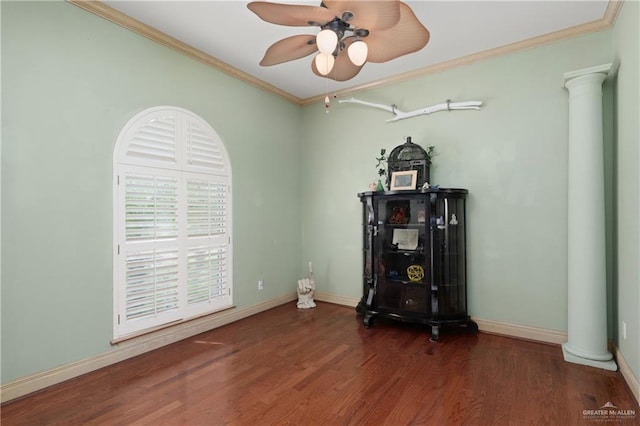 misc room with decorative columns, dark hardwood / wood-style floors, crown molding, and ceiling fan