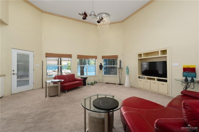 living room with light carpet, a high ceiling, a chandelier, and ornamental molding