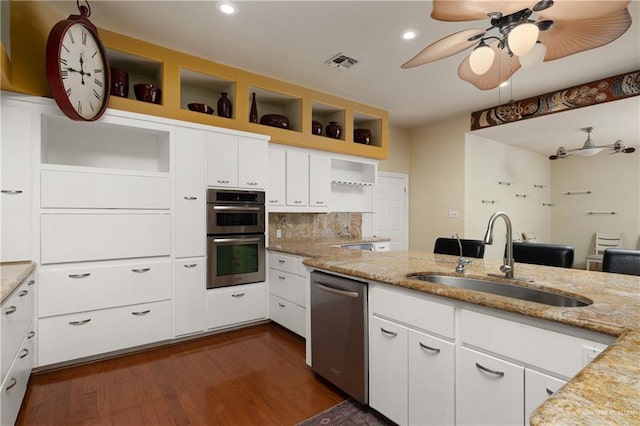 kitchen with white cabinets, sink, light stone countertops, tasteful backsplash, and stainless steel appliances