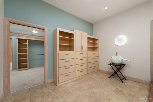 walk in closet with ceiling fan and light colored carpet