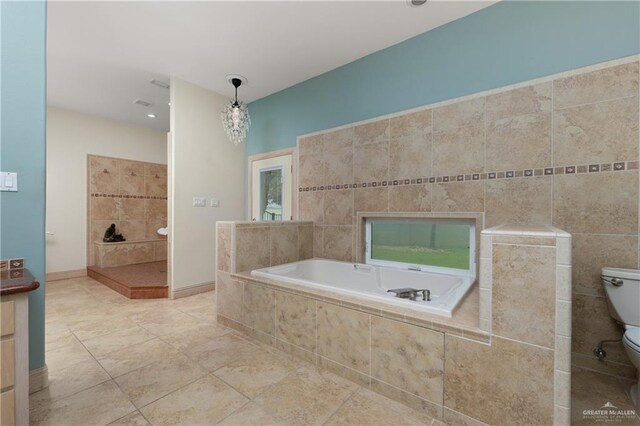 bathroom featuring an inviting chandelier, tile walls, tile patterned flooring, tiled bath, and toilet