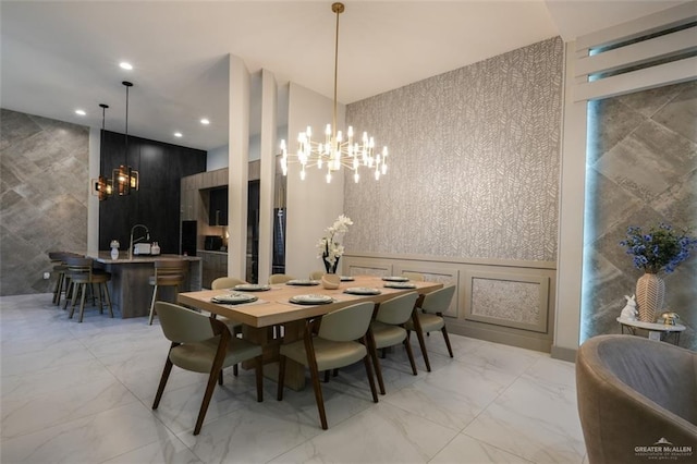 2511 Wisteria St, Mission, TX 78574 - dining area featuring a chandelier, light marble finish floors, recessed lighting, tile walls, and a decorative wall