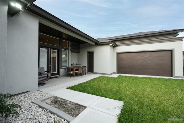 2511 Wisteria St, Mission, TX 78574 - rear view of property featuring stucco siding, a yard, and a garage