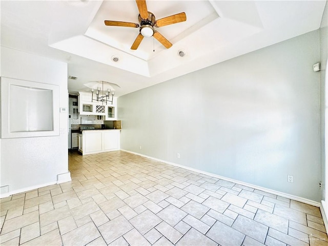 unfurnished room with ceiling fan and a raised ceiling