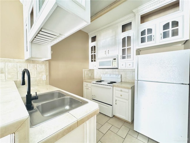 kitchen with white cabinetry, backsplash, white appliances, and sink