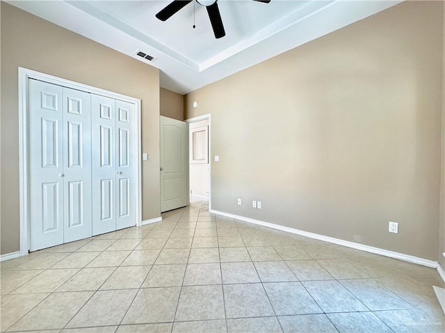 unfurnished bedroom featuring ceiling fan, light tile patterned floors, and a closet