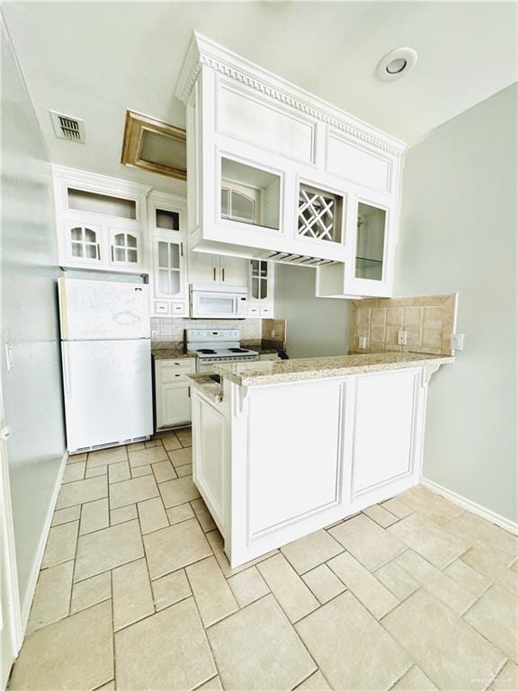 kitchen with white appliances, white cabinetry, kitchen peninsula, and backsplash