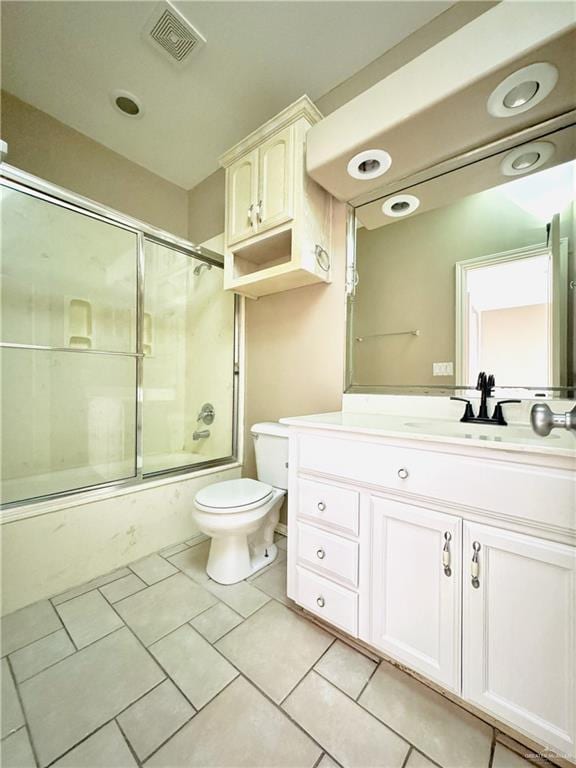 full bathroom featuring tile patterned floors, bath / shower combo with glass door, toilet, and vanity