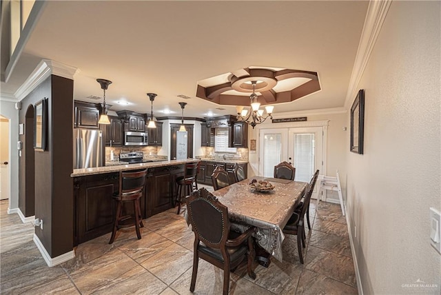 dining room featuring a raised ceiling, crown molding, french doors, and a notable chandelier