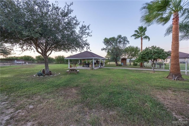 yard at dusk featuring a gazebo