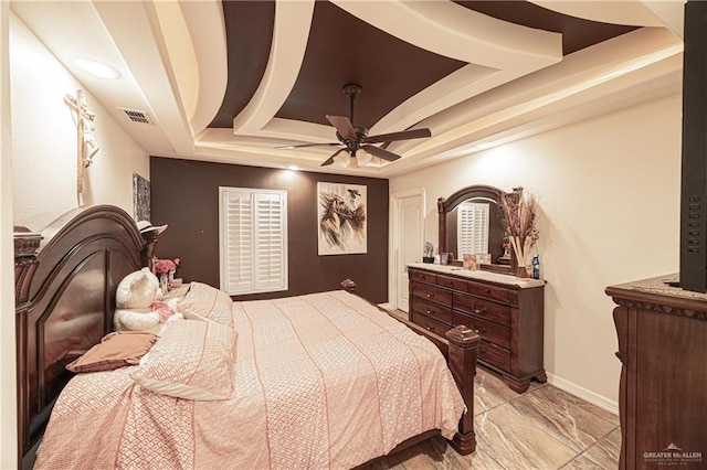 bedroom with a raised ceiling and ceiling fan