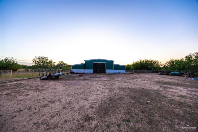 yard at dusk featuring an outdoor structure