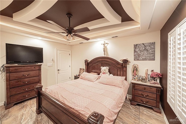 bedroom with a tray ceiling and ceiling fan