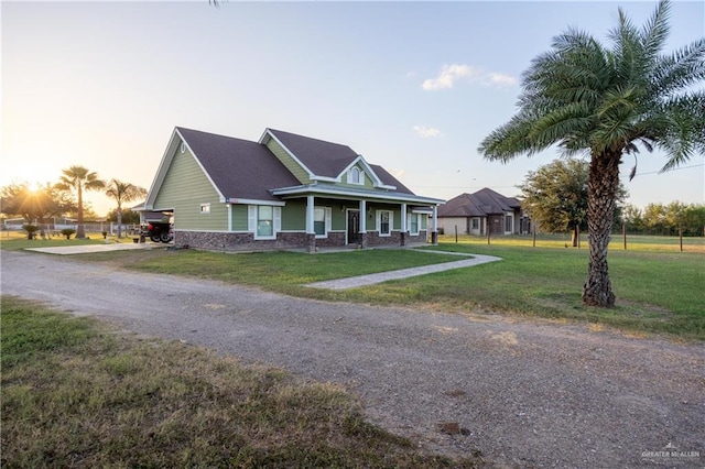 view of front of home with a porch and a lawn