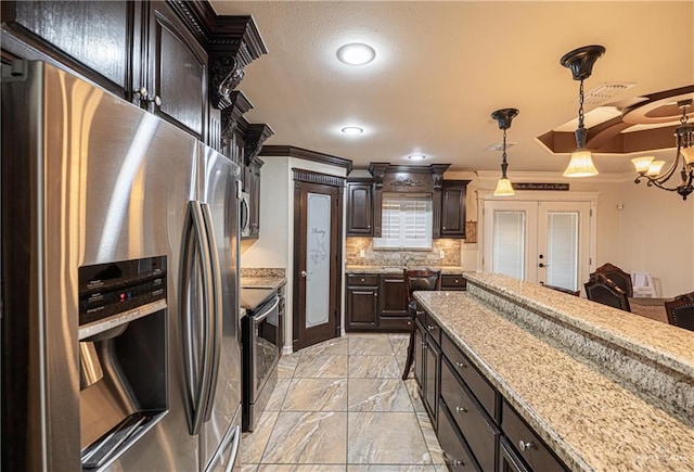 kitchen with dark brown cabinetry, stainless steel appliances, crown molding, a chandelier, and decorative light fixtures