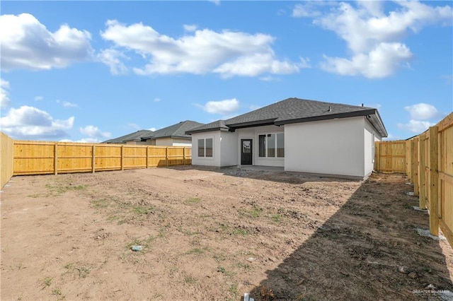 341 Leon Ave, Elsa, TX 78543 - rear view of house featuring a fenced backyard, stucco siding, and roof with shingles