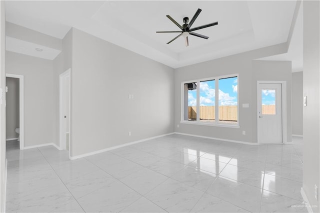 341 Leon Ave, Elsa, TX 78543 - unfurnished room featuring light marble finish flooring, ceiling fan, and a raised ceiling
